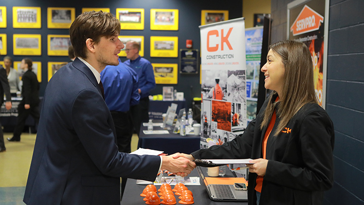 Following his interview, Simon Lavrincik, a freshman in civil engineering, shakes hands with Jackie Thompson, leader of talent acquisition with CK Construction, on Tuesday at the Spring 2025 Engineering Career Expo in Savage Arena.