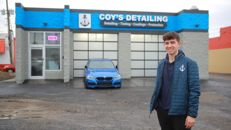 Caden Coy, a finance and management junior, who launched Coy’s Detailing in 2019, poses in front of his first shop at the corner of Byrne Road and Glendale Avenue, which he opened in December.