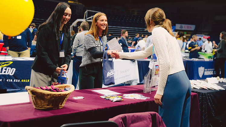 Two female student-athletes meet with a female recruiter during the Rockets Rise Networking and NIL Night.