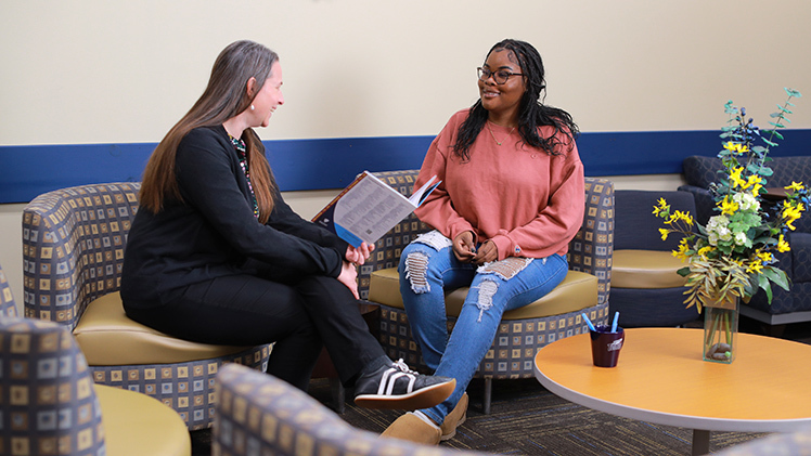 Photo of a female academic advisor talking with a female student at UToledo.