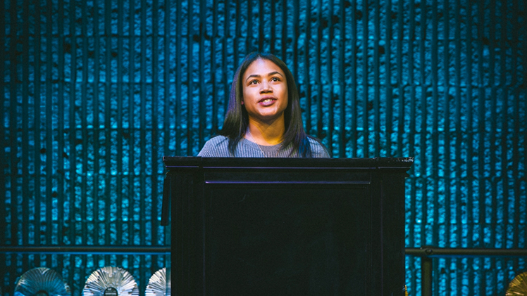 Photo of UToledo alumna Crystal Smith speaking at a podium after accepting the Toledo American Advertising Federation’s 2025 Mosaic Award for Most Promising Multicultural Student for her classroom work on a podcast and the UT10 student broadcasting news program.