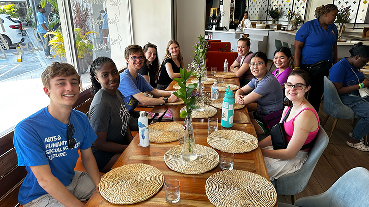 Over spring break, the Jesup Scott Honors College sent a group of honors students to Kingston, Jamaica, to help combat poverty and tackle infrastructure projects. The group of students is posing for a photo in a restaurant.