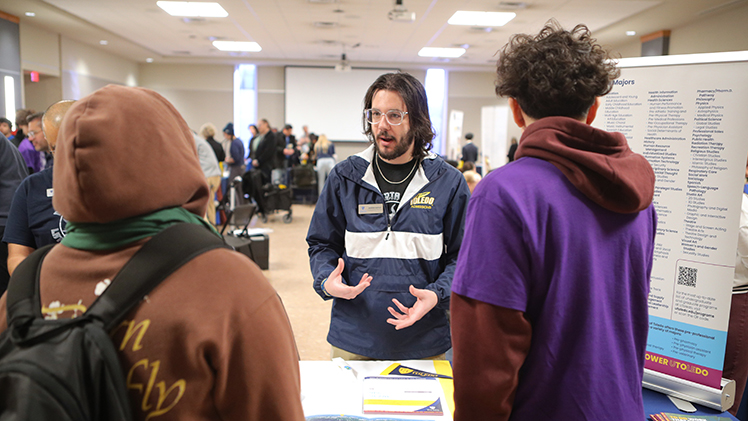 A University Admissions employee speaks with two high school students at UToledo's 2025 Latino Culture Summit.