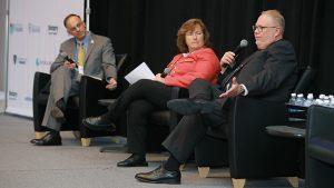 Dr. Michael Ellis, chief medical officer at UTMC, Dr. Dee Bialecki-Haase, chief medical officer and senior vice president for medical affairs at Medical Mutual, and Dr. Charles "Chuck" Callahan, executive vice president for health affairs at UToledo, sit on stage at the 2025 UToledo Healthcare Symposium.