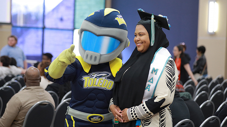 Jessica Smithers poses for a photo with Rocky before the start of the Multicultural Graduation ceremony on Saturday in Thompson Student Union Auditorium. Smithers is graduating with a bachelor’s degree in social work.