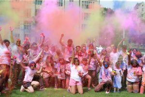 Heavily powdered revelers pose for a photo during Holi Toledo.
