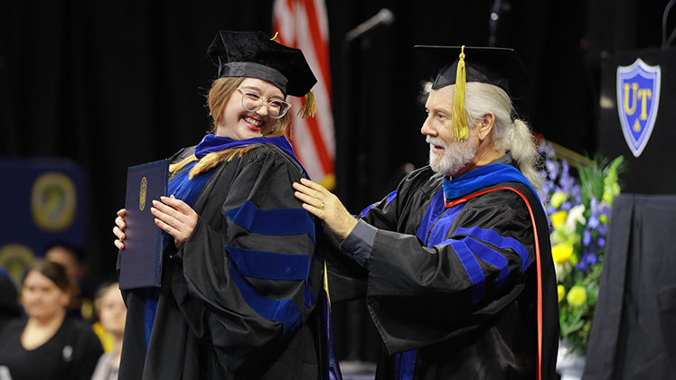 Elyse Hutcheson is hooded by Dr. Wesley Bullock, an associate professor in the Department of Psychology, during Friday’s doctoral hooding and graduate ceremony in Savage Arena. Hutcheson was graduating with a Ph.D. in psychology.