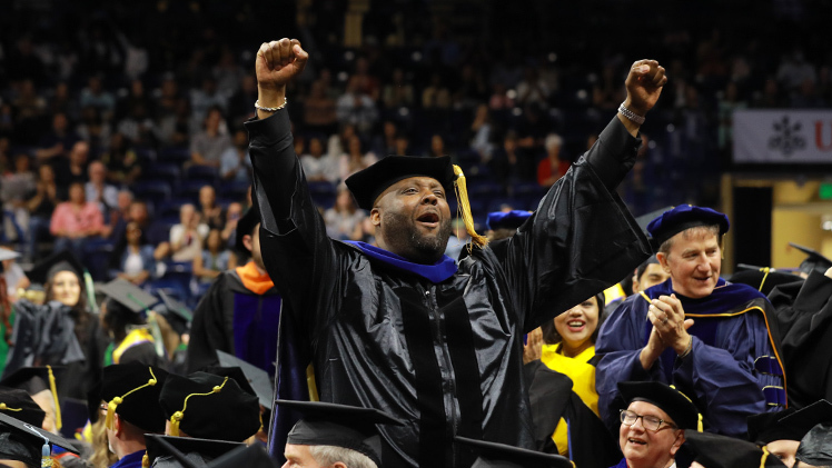 Kelvin Freeman celebrates as the Savage Arena audience cheers for the graduates. Freeman was graduating with a doctor of philosophy in health education.
