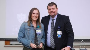 Ashley Walton, a UTMC lead nurse, stands next to Ken Fry, the assistant chief nursing officer, and holds the glass award she received as day shift nurse of the year. 