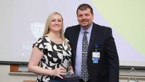 Laura Eubank, a lead nurse at UTMC, stands next to UTMC assistant chief nursing officer Ken Fry and holds a glass award she received as night shift nurse of the year.