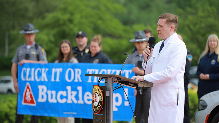 Dr. Alastair Hoyt, a UToledo Health neurosurgeon, talks about the danger posed by unbelted crashes during a kick off for the annual Click It or Ticket campaign Monday outside UTMC.