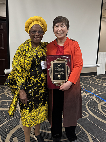 Dr. An Chung Cheng, right, received the 2025 Walton Award from Dr. Antonia Schleicher, executive director of the National Council of Less Commonly Taught Languages, during the council’s conference in late April.