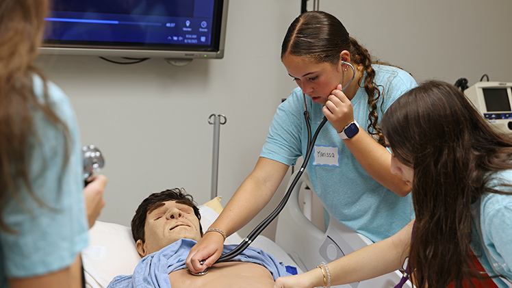 Marissa Morgan listens for a simulated heartbeat during the CPR session of Rocket Nursing Camp.