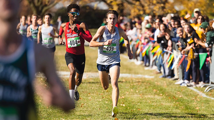 Taylor passes a runner from Miami during the 2024 MAC men's cross country championship to secure Toledo's first-ever conference title.
