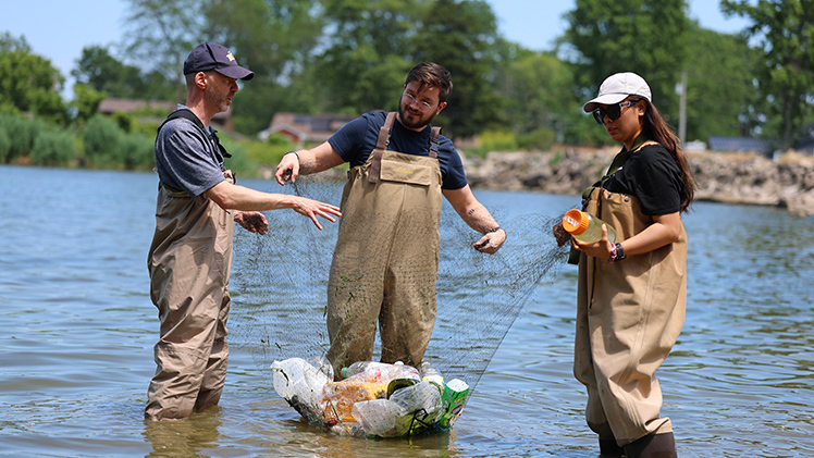 Dr. David Kennedy, a professor of medicine, and doctoral students Benjamin French and Upasana Shrestha hold a net full of plastic waste at the UToledo Lake Erie Center. French and Shrestha were part of a UToledo research team led by Kennedy that examined the risks of inhaling microscopic plastic particles.