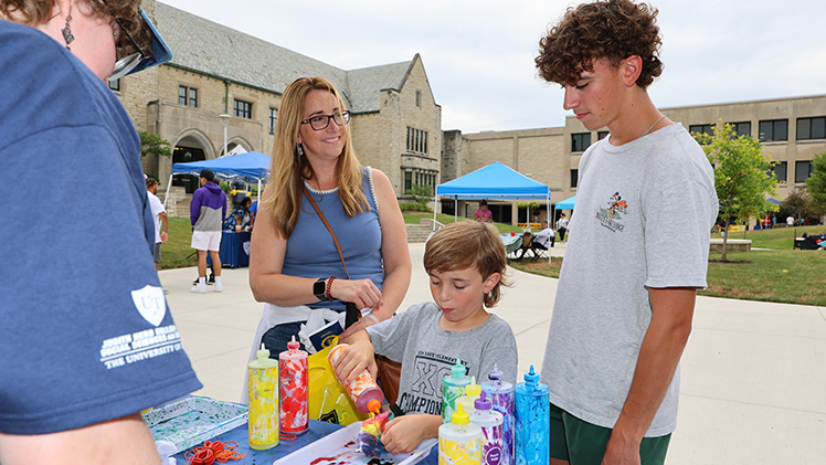 Jillian Lewis smiles at her son Jack, from Sylvania Southview High School, as her son Cody, 7, creates a tie-dye T-shirt.