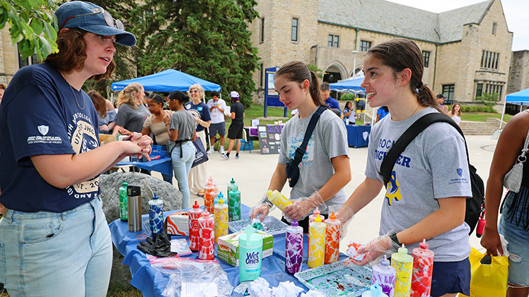 Sisters Julia, left, and Jenna Chryst, from Notre Dame Academy, enjoy making tie-dye T-shirts at one of the activities during Friday’s Campus Crawl.