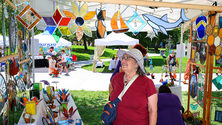 Beatrice Maugeri, from Toledo, admires some of the stained glass in artist Judi Kempf’s tent.