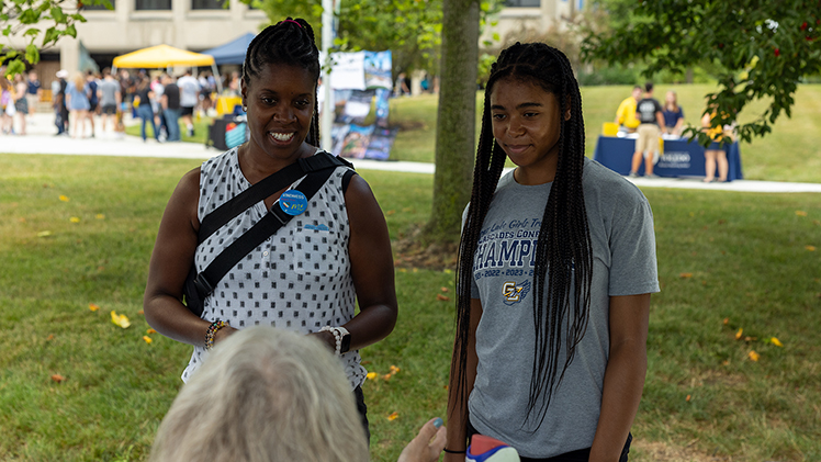 A prospective student and her mother talk with the Office of Accessibility and Disability Resources staff tabling at Campus Crawl.