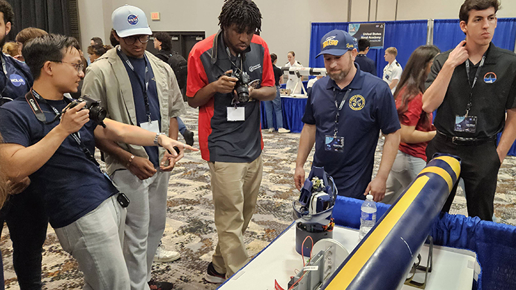 Mike Vargas, a master’s student in mechanical engineering, discusses the innovative payload system that he and his peers designed during the Rocket Fair event at the 2025 NASA Student Launch Challenge.