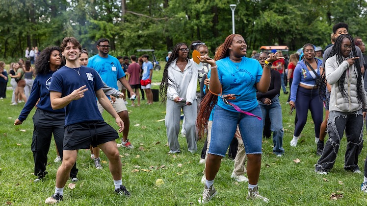 A group of students, including Cyler Amor, a junior mechanical engineering major, and Randi Pike, a sophomore social work major, dance at the annual Residence Life bonfire in the Flatlands.