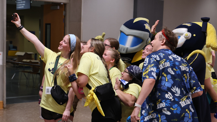 Counselor Grace Drake, a second year pre-occupational therapy major, takes a selfie with other counselors and Rocky and Rocksy.