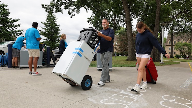 Freshman neuroscience major Teyghyn Roesner walks alongside her dad, Andy Roesner, as she moves into Parks Tower.