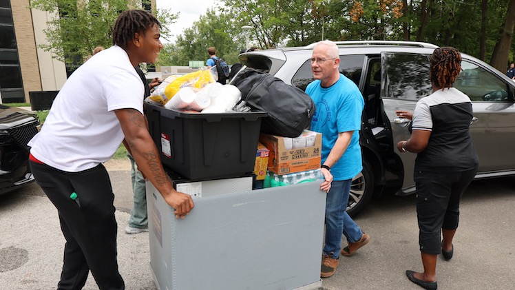 Dr. James Holloway and Carlos Hazelwood, a sophomore majoring in criminal justice and defensive tackle on the Rockets football team, maneuver a moving cart during UToledo's move-in week. 