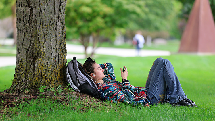 Clare Logan, a senior psychology student, relaxes under a tree on Centennial Mall during an afternoon break on Monday, the first day of classes for the fall 2025 semester.