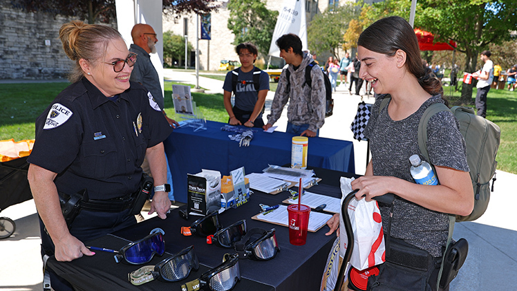 Officer Jeanette Gerber of the UToledo Police Department and Gracyn LaPlante, a biology senior, share a laugh during the Campus Involvement Fair on Wednesday, Aug. 27.