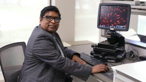 Dr. Charles Thodeti, professor in the College of Medicine and Life Sciences, sits at a digital microscope in his lab on UToledo's Health Science Campus. 