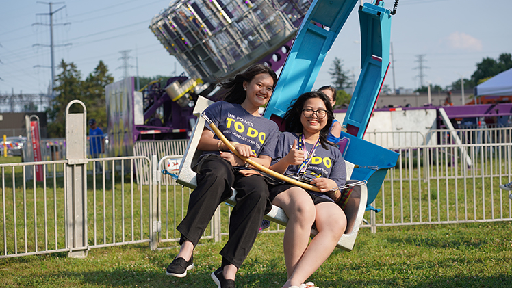 Mai Mguyen, a freshman in cosmetic science, and Thao Thran, a freshman in pharmacy, enjoy a swing ride at the carnival.