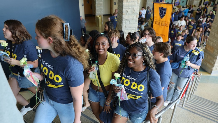 Smiling first-year students climb the stairs in Savage Arena during the University's annual new student convocation. 