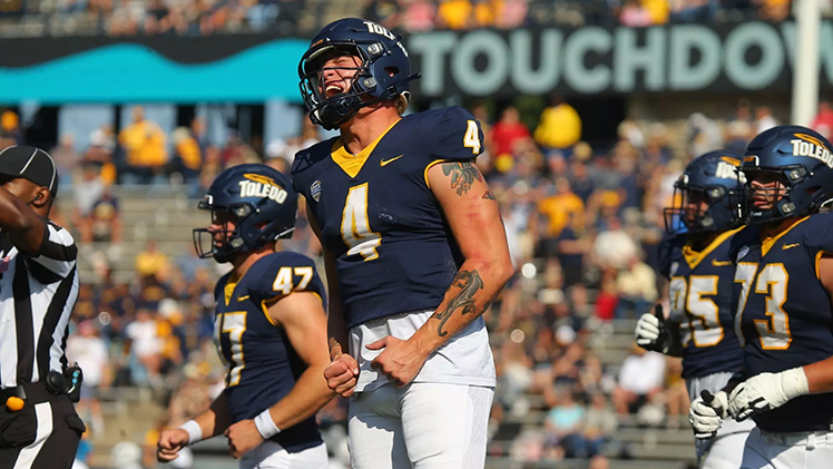 Photo of Toledo QB Tucker Gleason celebrating after a play during a game.