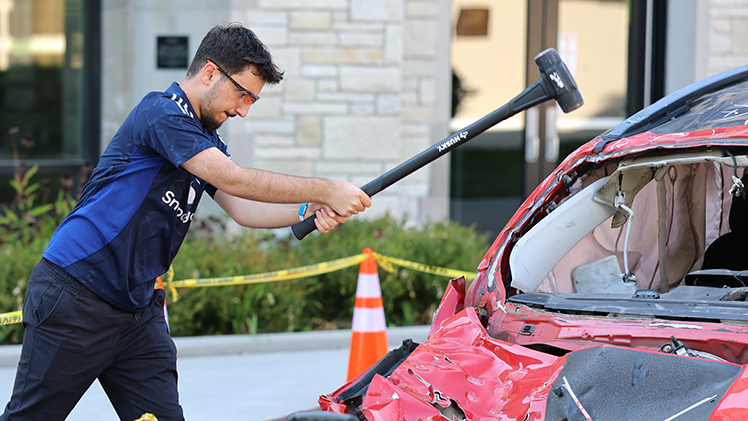 Majd Al-Hurr, a freshman studying pharmacy, takes his turn at demolishing a car on Thursday at Centennial Mall as part of Light Up the Night.