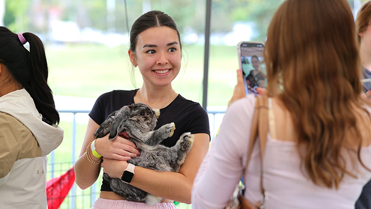 Chloe Mackowski, a pre-nursing freshman, holds a bunny as she poses for a photo.
