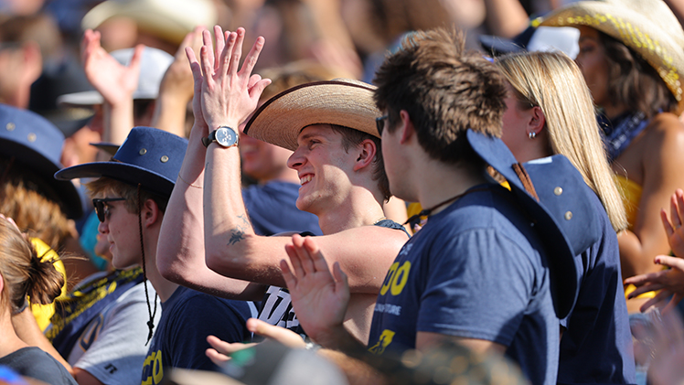 Students clap during the Homecoming game.