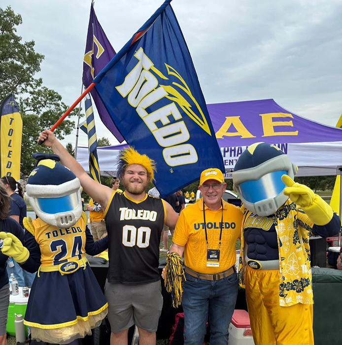 Senior nursing student Chase Gillson poses with UToledo president James Holloway at a tailgating event before a home football game. Both are wearing Rocket gear.