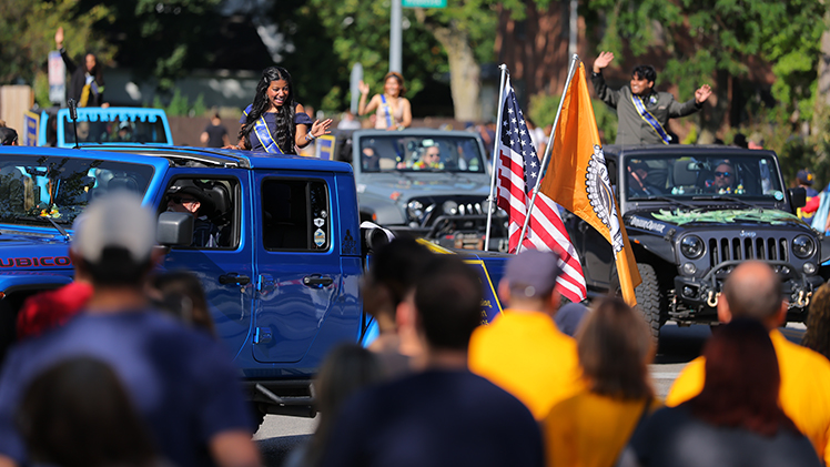 Photo of the UToledo Homecoming Court riding in Jeeps in the annual Edward C. and Helen G. Schmakel Homecoming Parade.