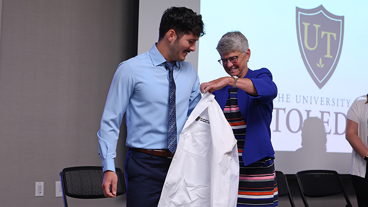 Dylan Hershey, an incoming student in UToledo’s Doctor of Physical Therapy Program, is helped into his new white coat on Aug. 21 by Dr. Cindy Bouillon, associate professor and director of the D.P.T. program. The College of Health and Human Services also hosted a white coat ceremony for students in the Bachelor of Science in Nursing Program on Tuesday.