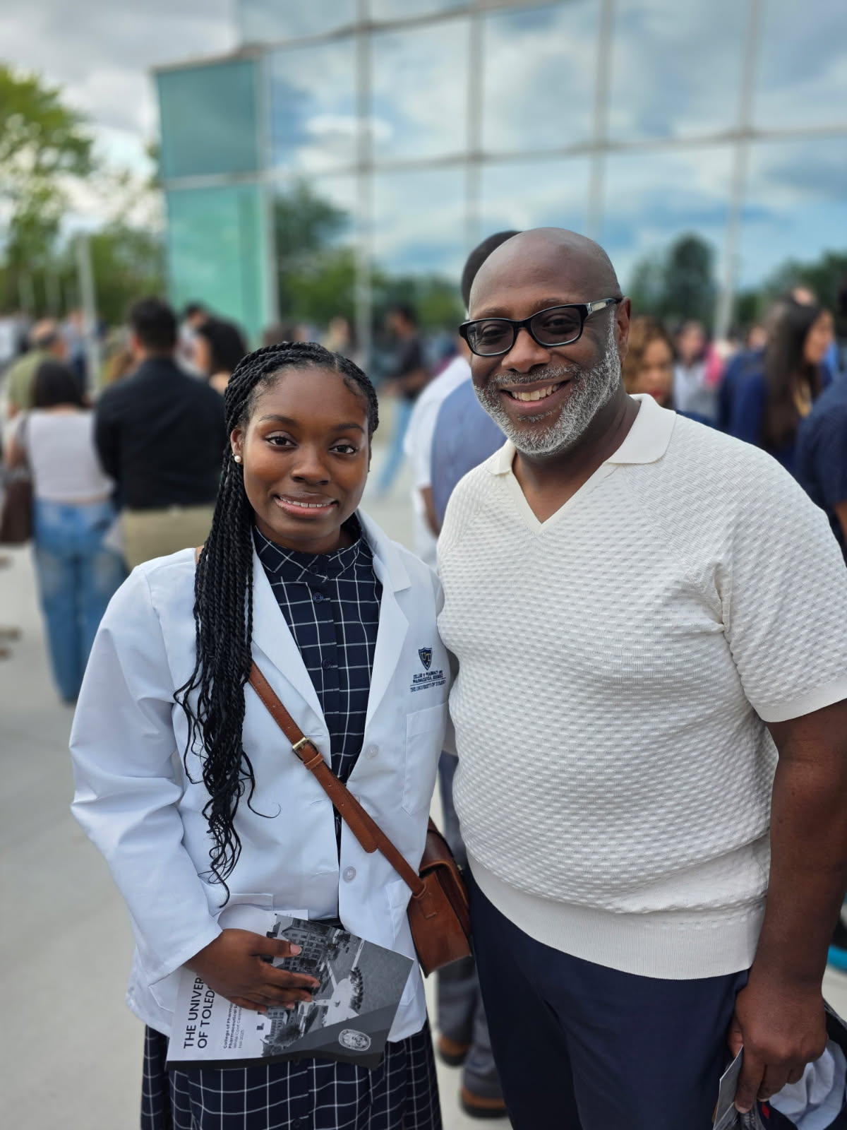 Craig Turner, right, director of the Y.E.S. Program, joined Laila Fitzpatrick, a pharmacy junior, and her family for her milestone white coat ceremony in August.