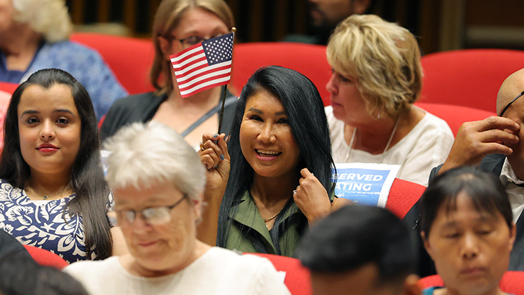 Natthakorn Heilman was among the new citizens who celebrated her new status by waving a U.S. flag.