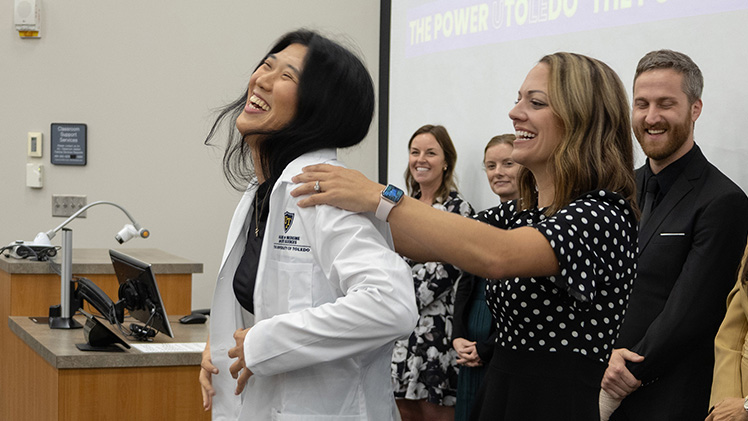Katherine Wang, an incoming student in the Physician Assistant Program smiles as she receives her white coat from assistant professor Kim Kaczmarek during the program’s white coat ceremony on Aug. 22. Wang and her fellow students will spend the next 27 months earning their Master of Science in Biomedical Sciences degree with a physician assistant concentration.