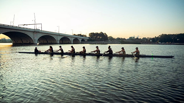 Photo of the Toledo Women's rowing team practicing rowing on the Maumee River at dawn.