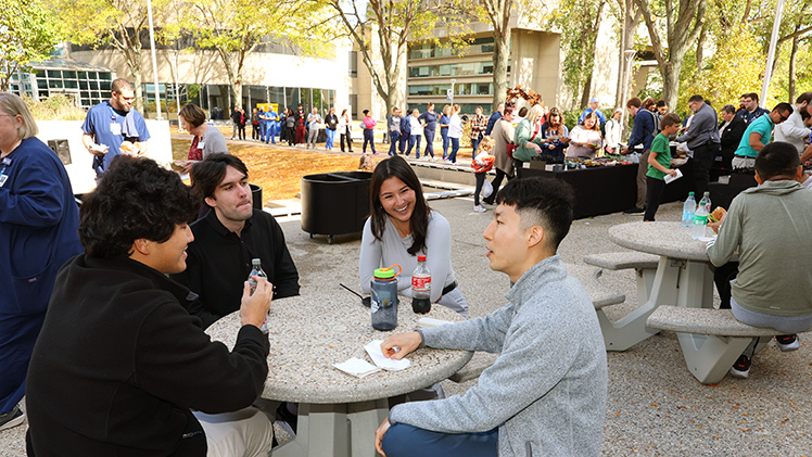 The president’s barbecue provided a respite between classes for third-year medical students, from left, Thomas Cho, Lucas Ratiani, Katie Beier and Young Min Yu.