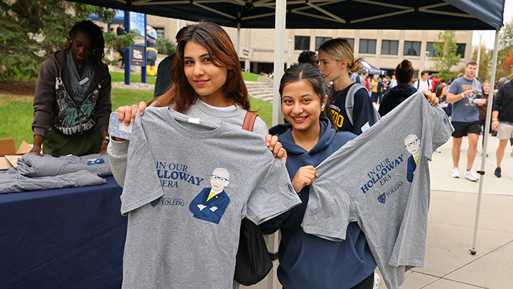 From left, Simran Giri, a freshman in information systems, and Subina Sapkota, a freshman in pre-nursing, show off their “In Our Holloway Era” UToledo T-shirts, which were given out at the barbecue.