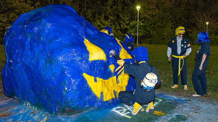 Members of Blue Crew put the finishing touches on Spirit Rock on Monday night in the Flatlands, turning the iconic rock into a festive jack-o’-lantern painted in UToledo colors to help kick off a week of campus events as part of Holloways Halloween. 