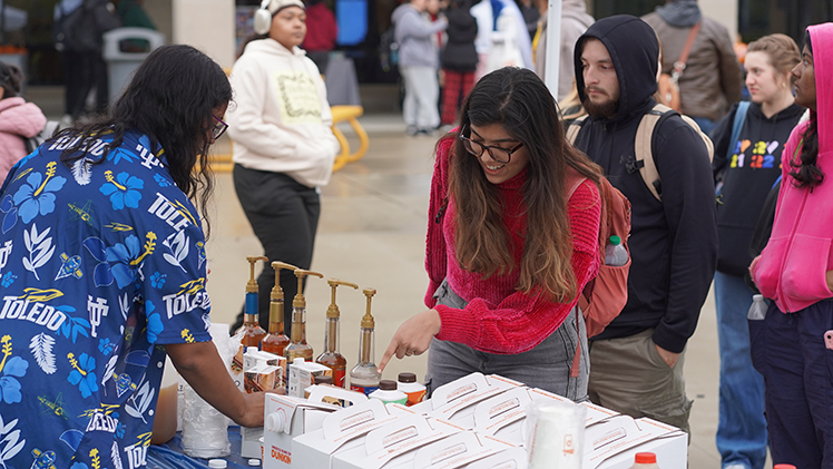 Sree Kakarala, a senior in biology, serves hot chocolate to Rupika Arora, a senior in biomedical engineering.