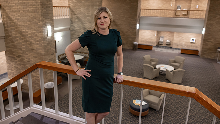 Portrait of third-year law student Jessica Creekmore, who is posing on the second-floor stairs in UToledo's College of Law building.