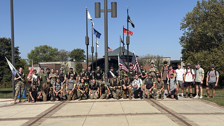 Student Veterans of America groups at The University of Toledo and Bowling Green State University pose together for a group flag while holding various flags. The student groups joined forces last Saturday to deliver and present the game ball to officials in their third annual “Ruck the Ball” 24-mile march leading up to the annual Battle of I-75 football matchup between the Rockets and the Falcons at Bowling Green this Saturday, Oct. 11. The march aims to bring attention to the issue of the high suicide rate among our nation’s veterans.